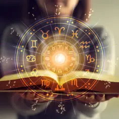 Otwarta księga z kręgiem znaków zodiaku. Sprawdź swój horoskop na jutro byk i odkryj przyszłość.