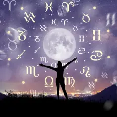 Sylwetka osoby z rozłożonymi rękami pod księżycem, otoczona znakami zodiaku. 22 listopada znak zodiaku to Strzelec.