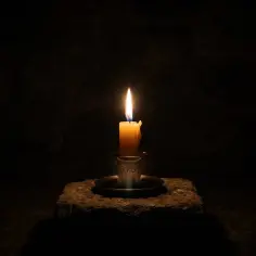Płonąca świeca na kamieniu, symbolizująca północ, 00:00 znaczenie.
