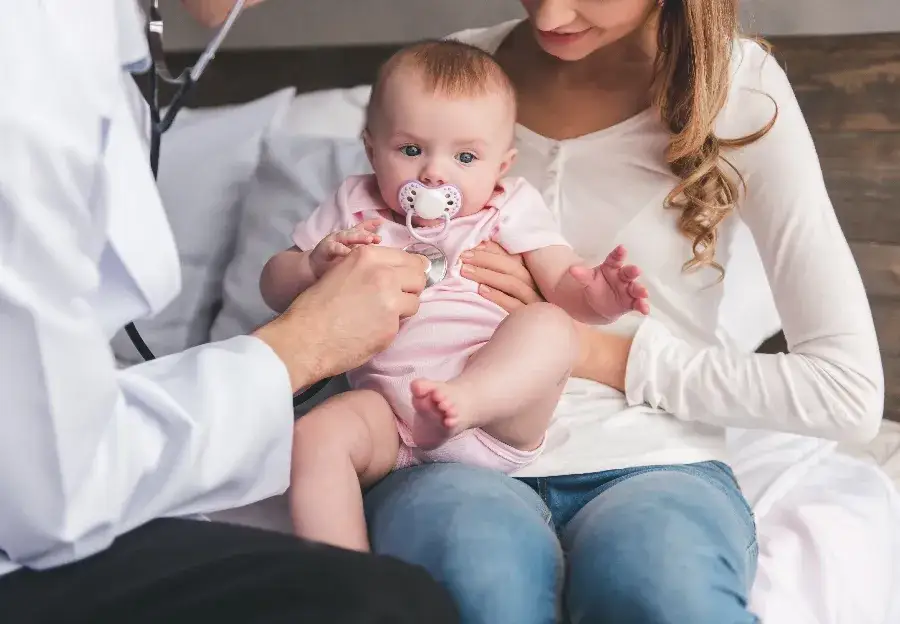 zaniepokojeni rodzice z niemowlakiem, lekarz pediatra i dziecko