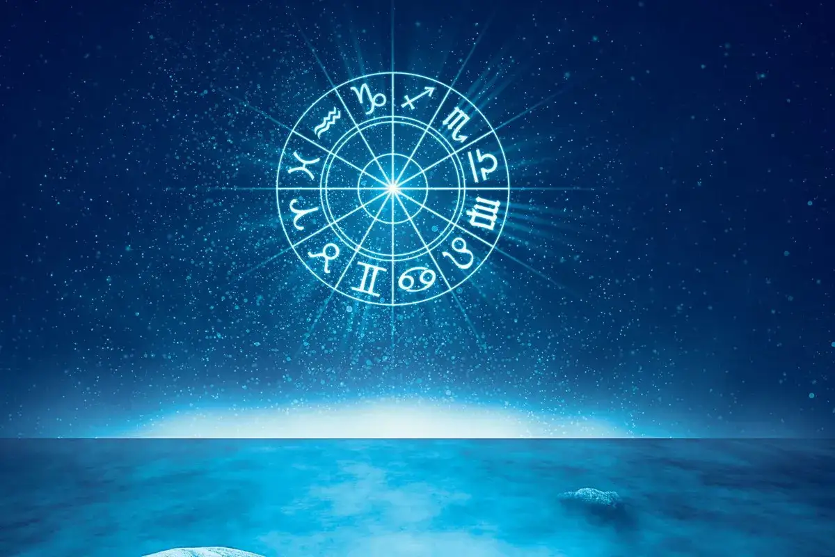 Jasny krąg z symbolami znaków wodnych zodiaku na tle nocnego nieba i spokojnego morza.