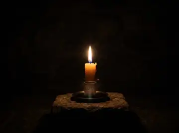 Płonąca świeca na kamieniu, symbolizująca północ, 00:00 znaczenie.